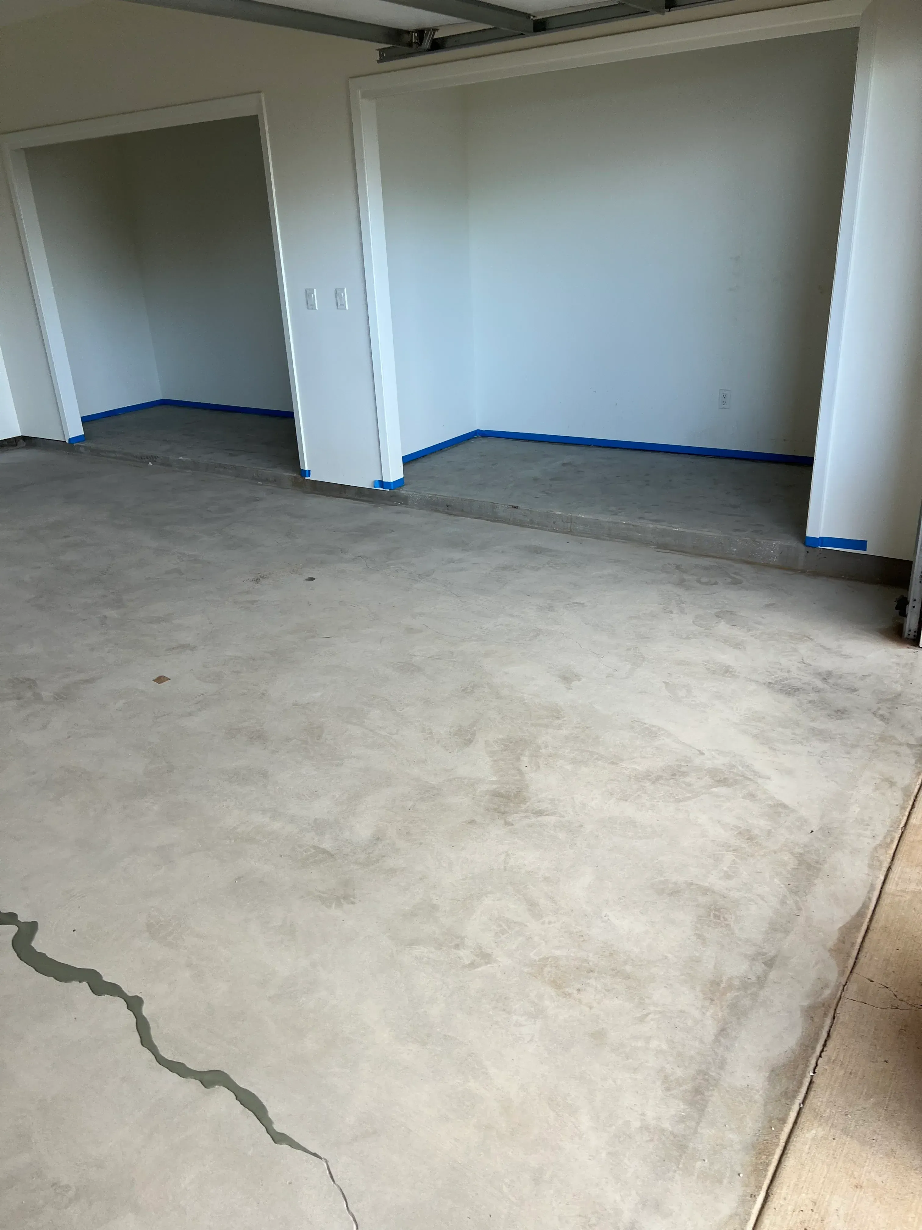 Concrete floor preparation with blue masking tape and finished substrate surface