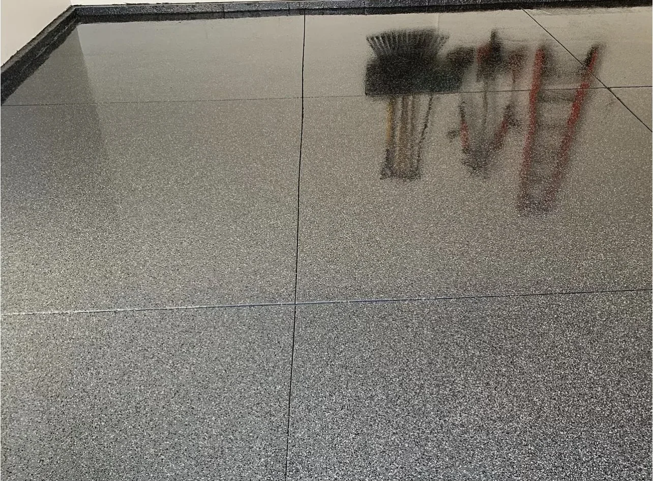 Polished concrete floor with gray aggregate finish and dark trim border