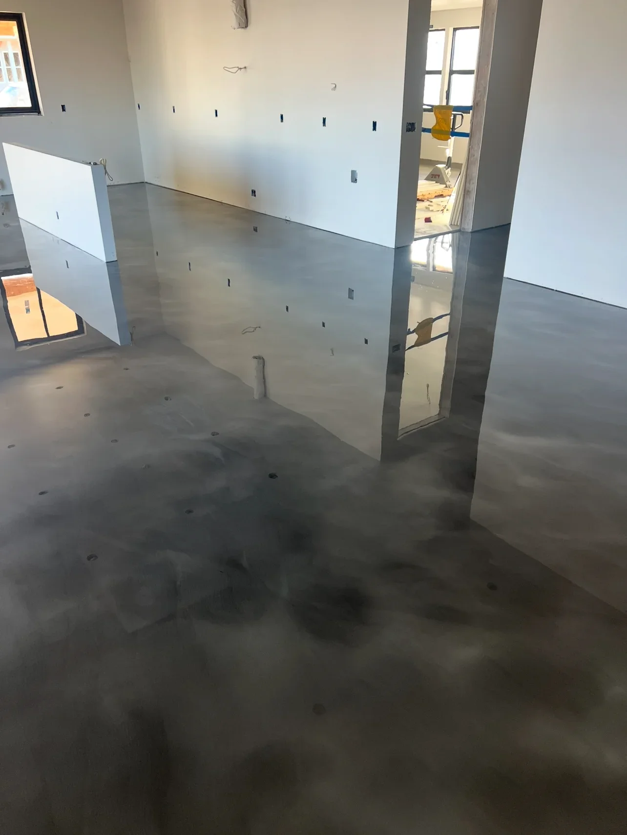 Polished concrete floor in commercial space with drywall framing and structural columns