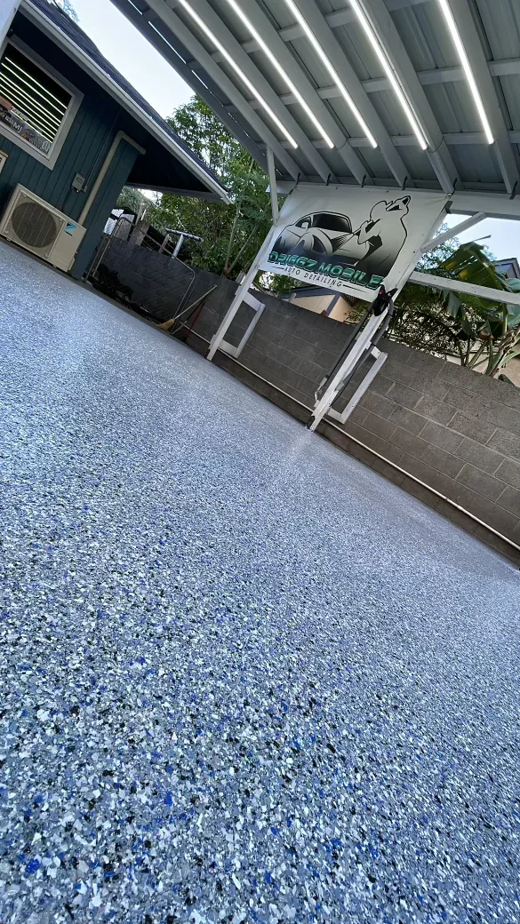 Blue and white epoxy aggregate flooring under aluminum pergola structure
